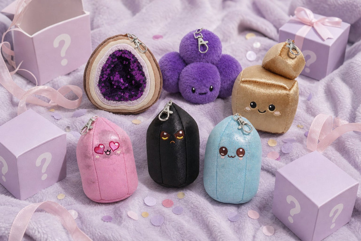 Crystal Plushie bag charms tumbled together with pastel mystery boxes on a lilac blanket