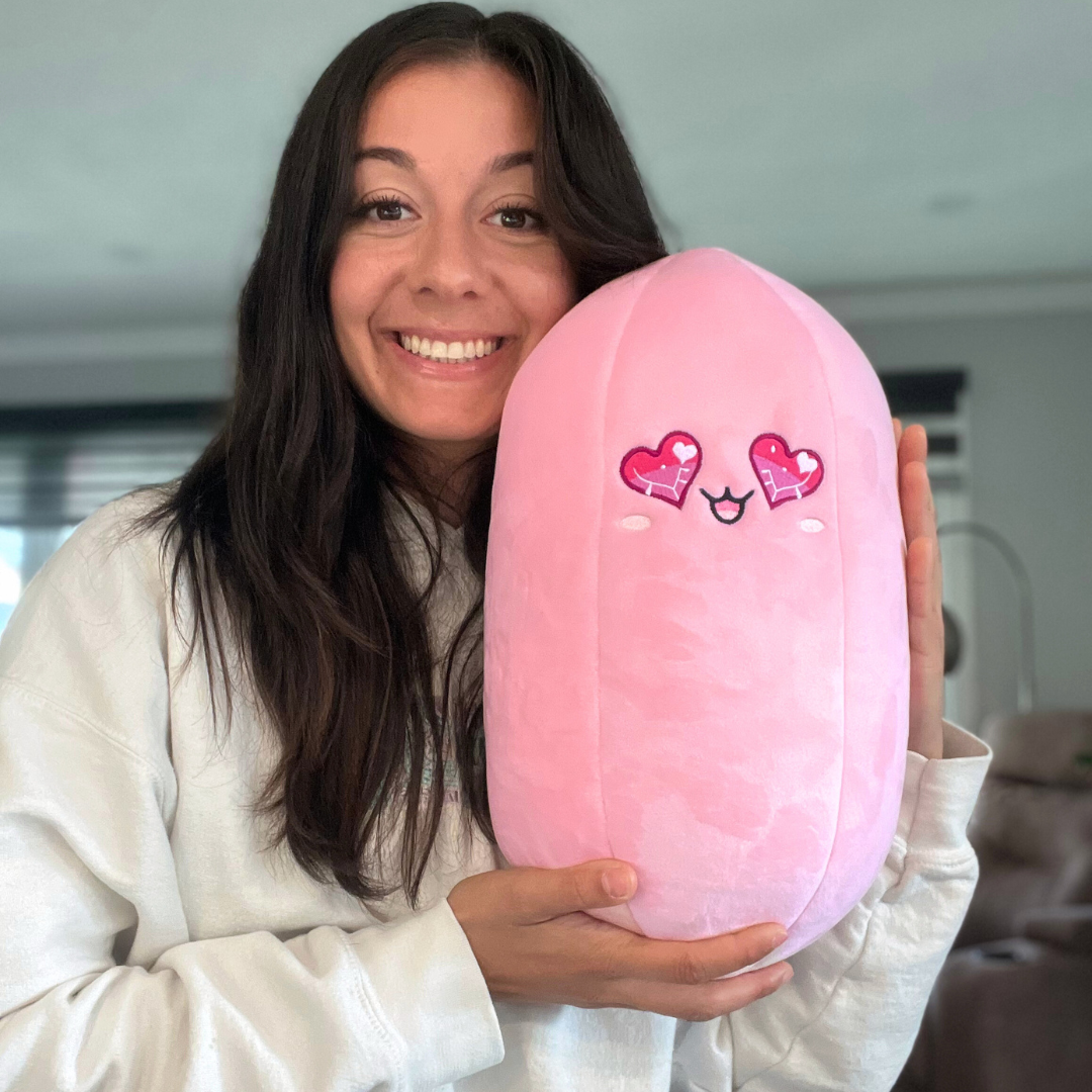 A smiling woman hugging Rosie the Rose Quartz Crystal Plushie