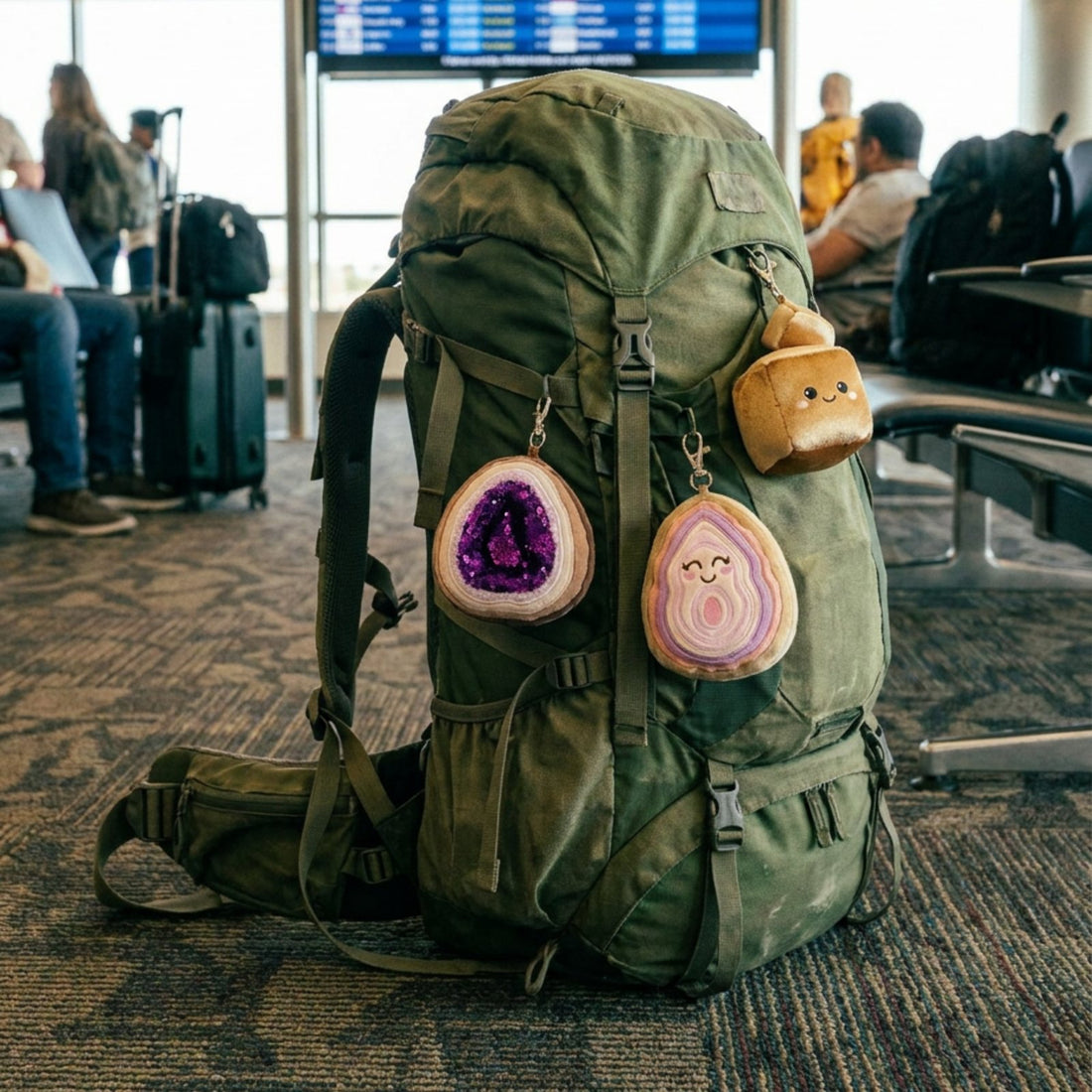 Violet, Archie and Sparky bag charms clipped to a backpack at the airport